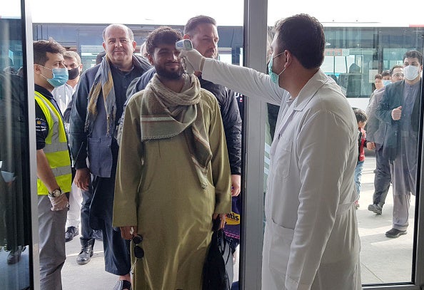 A medical officer scans a passenger for signs of fever at a bus station as a precaution against the coronavirus in Kabul, Afghanistan, March 27, 2020. © 2020 Sayed Khodaiberdi Sadat/Anadolu Agency via Getty Images