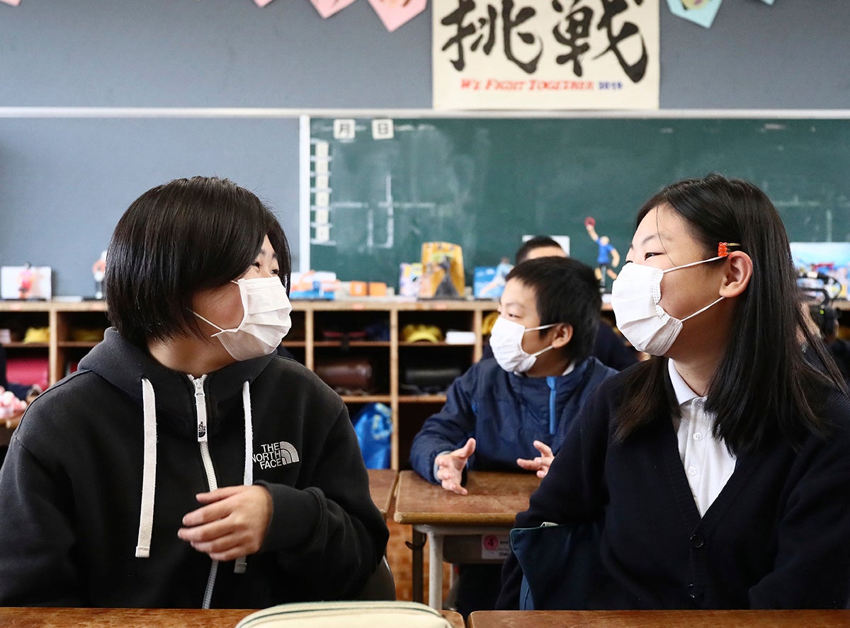 Des élèves japonais portent des masques dans une école à Mashiki (préfecture de Kumamoto), le 15 mars 2020, peu avant l’annulation des cours en raison du coronavirus et des risques liés au COVID-19. 