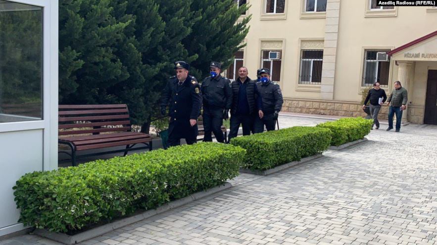 Policemen bringing the opposition leader Tofig Yagublu to Nizami District Court of Baku.