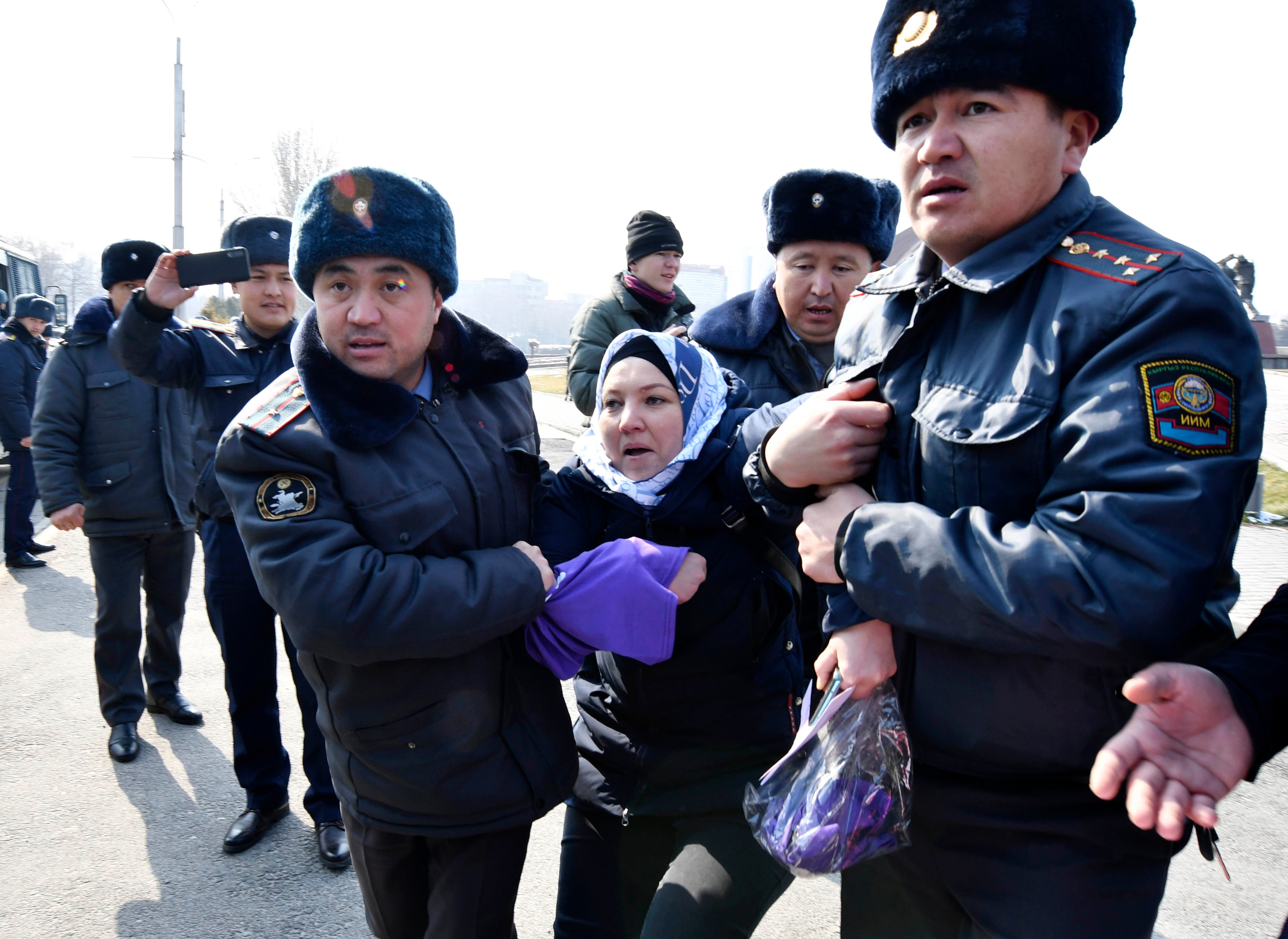 Кыргызские милиционеры задерживают активистку женского правозащитного движения "Femen" на площади Победы во время празднования Международного женского дня в Бишкеке в воскресенье, 8 марта 2020 года.