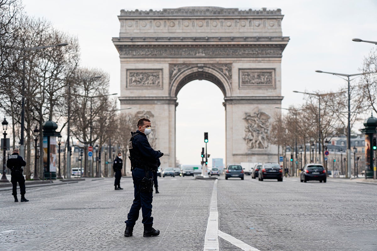 Police patrol near the Arc de Triomphe on the first day of confinement due to COVID-19, Paris, France, March 17, 2020.