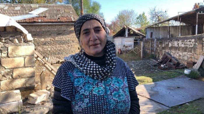 Interviewee stands in front of ruins