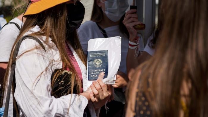 A Belarusian woman holds her passport outside the Belarusian Embassy in Warsaw, Poland, August 9, 2020. 