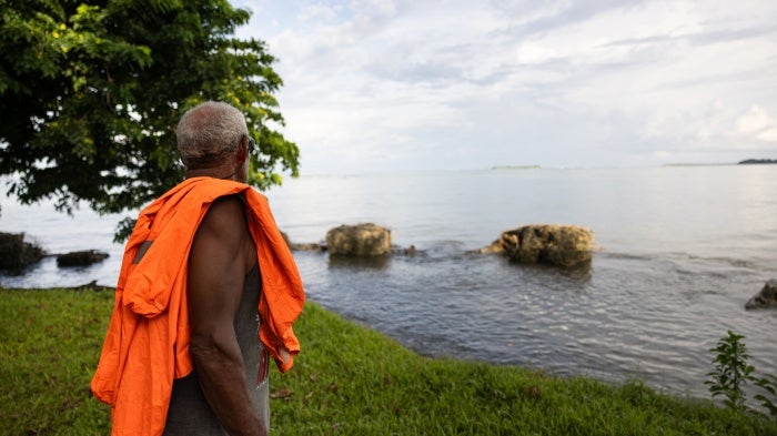 Community leader looks out to the seawall that has recently fallen apart and no longer protects the village of Walande, Malaita Province, Solomon Islands. 