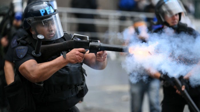 A riot police officer shoots a tear gas canister at protesters during a demonstration of pensioners calling for improvements to their pensions and access to free medicines, among other demands, in Buenos Aires on March 12, 2025.