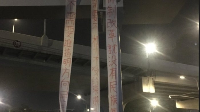 Three pro-democracy banners hang from an overpass outside the Chengdu Chadianzi Station in China’s Sichuan province on the morning of April 15, 2025.