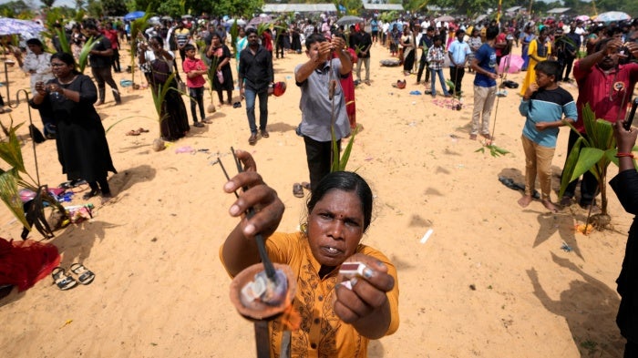 People perform rituals in memory of their deceased or missing relatives on a beach