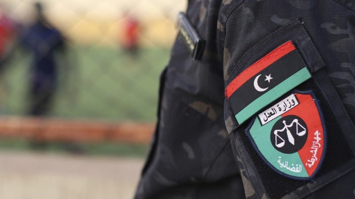 عنصر في الشرطة القضائية الليبية يحرس محتجزين في مصراتة، ليبيا، 27 أبريل/نيسان 2022. 