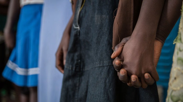 Girls who had been abducted by armed groups and forced to cook in captivity during conflict in Yambio, South Sudan, hold hands during a ceremony marking their release from captivity on February 7, 2018. 