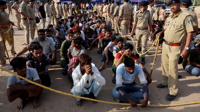Police officers detain alleged undocumented Bangladeshi nationals after they were arrested during raids in Ahmedabad, India, April 26, 2025.