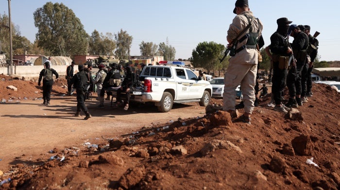 Syrian government security forces stand atop an earth barrier that they created as a buffer during their deployment in Busra al-Harir in Syria’s southern Daraa province on July 21, 2025.