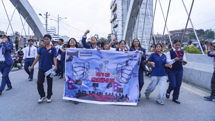 A row of students hold a protest banner which reads "Let's go Gen Z, protest against corruption"