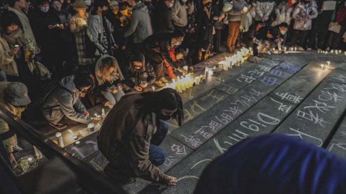 A protester writes "dignity" in English and Chinese in a show of solidarity with the White Paper protest in China at the University of Washington in Seattle, December 4, 2022.
