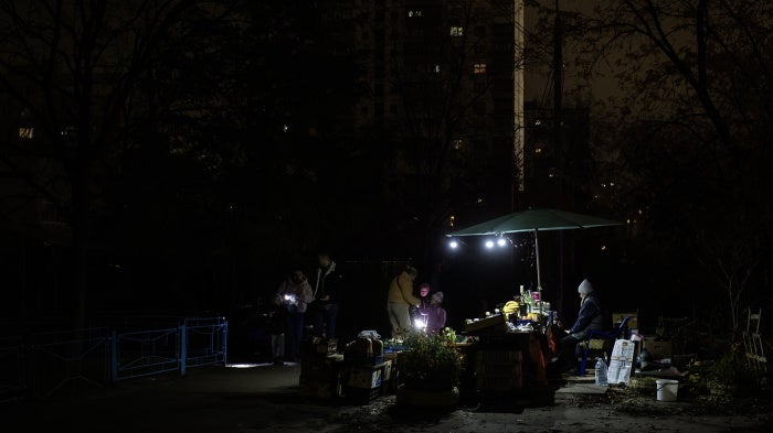 A fruit and vegetable stall in a residential neighborhood is illuminated by small lamps during a blackout caused by Russia’s attacks on Ukraine’s power infrastructure, in Kyiv, Ukraine, on November 6, 2025.