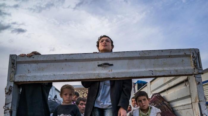 SEPTEMBER 2014. Syrian Kurdish refugees look out from the back of a truck as they enter Turkey from the town of Kobane (Ayn al-Arab), Syria, and surrounding villages. © 2014 Michael Christopher Brown/Magnum
