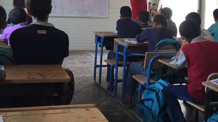 Syrian children attend class in a school in the Zaatari refugee camp in northern Jordan, October 20, 2015. The school taught Syrian girls in the morning and boys in the afternoon, but lacked electricity, heating, and running water. 