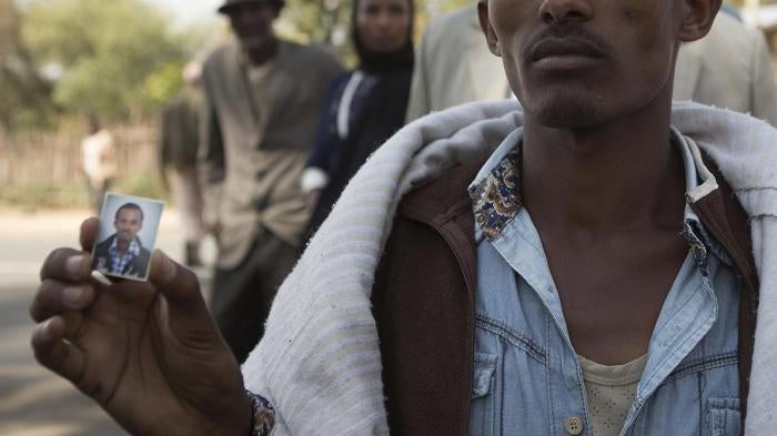 Mersen Chala holds a photo of his brother Dinka, who was killed by Ethiopian security forces a day earlier, in Yubdo village, Oromia region, about 100 kilometers from Addis Ababa, December 2015.