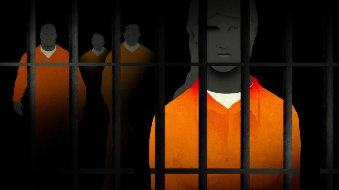 prisoners stand behind bars 