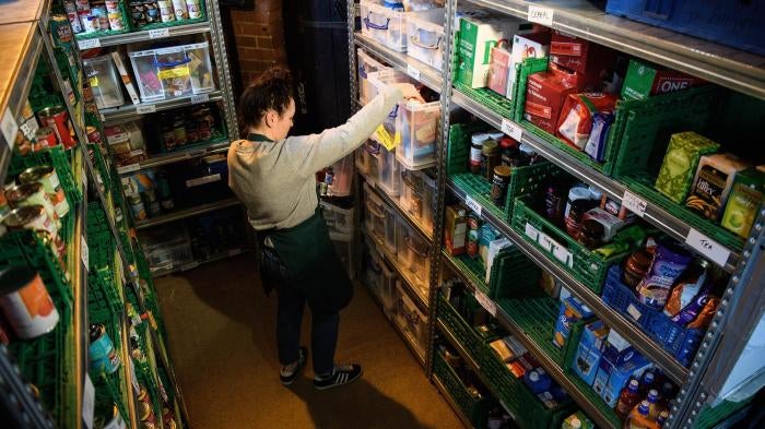 A volunteer at a Trussell Trust food bank prepares food parcels from their stores of donated food, toiletries and other items. London, United Kingdom. 