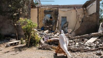 A woman walks past a house that was damaged by shelling when federal-aligned forces entered the town of Wukro, in Ethiopia's Tigray region, March 1, 2021. 