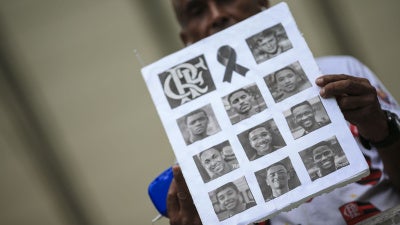 A fan shows photos of athletes of died