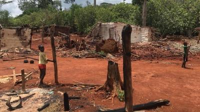 Children stand among houses burnt during an eviction operation in the protected forest of Goin-Débé, Côte d'Ivoire, in January 2016.