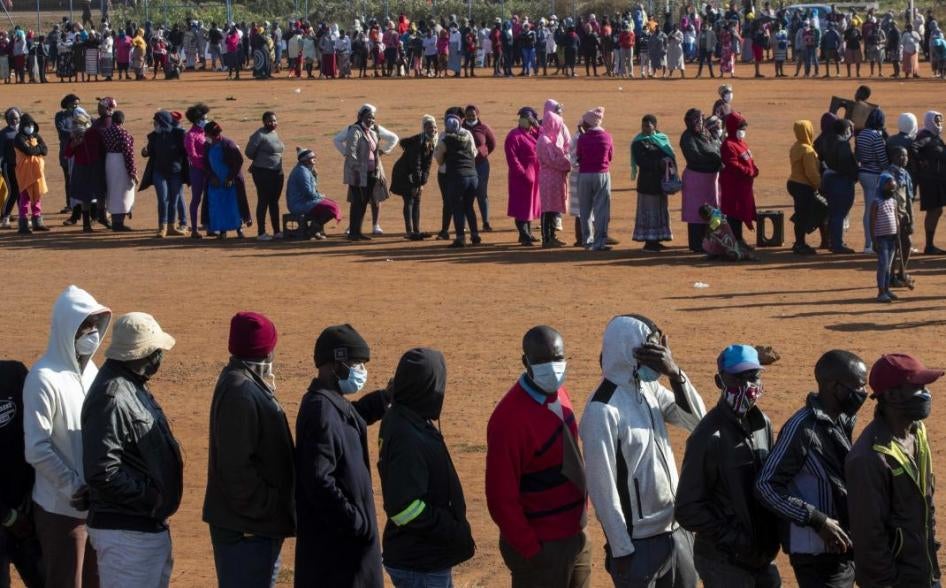 People affected by the coronavirus economic downturn, line up to receive food donations at the Iterileng informal settlement near Laudium, southwest of Pretoria, South Africa, Wednesday, May 20, 2020.