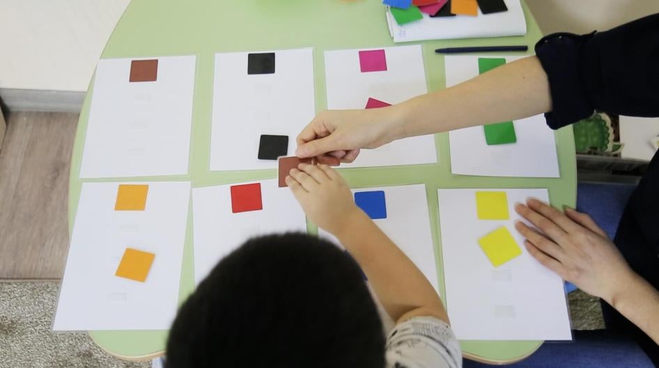 A teacher and a child match squares at Balama Center, an organization that offers support to children with autism in Almaty, Kazakhstan.