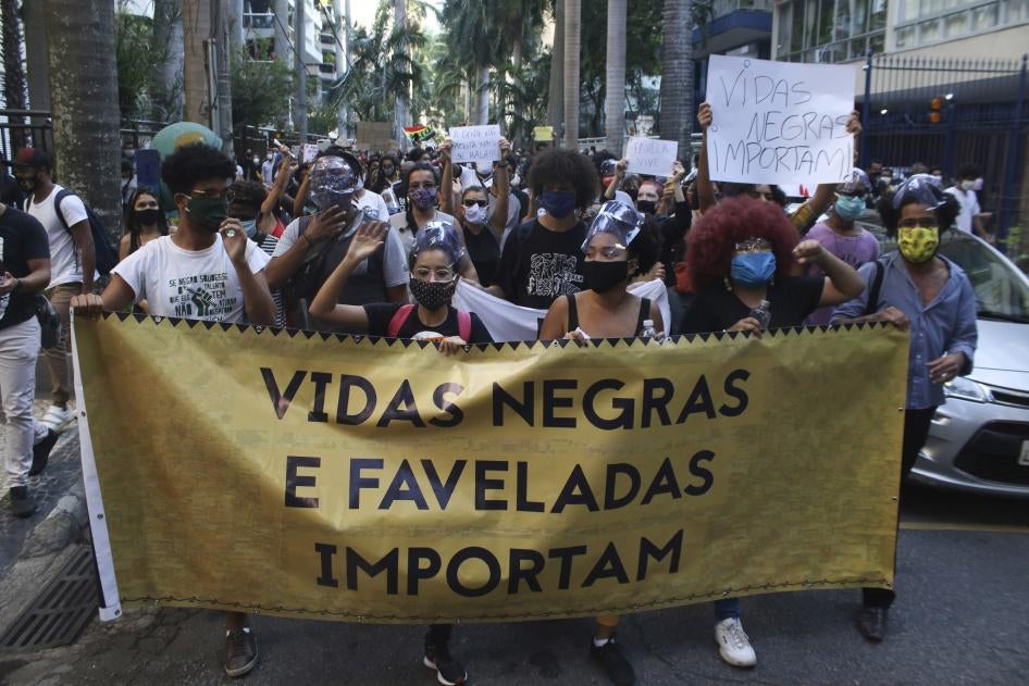 People protest against police killings in front of the Guanabara Palace, the residence of the Rio de Janeiro State Governor, on May 31, 2020. One sign reads “Black Lives Matter.”
