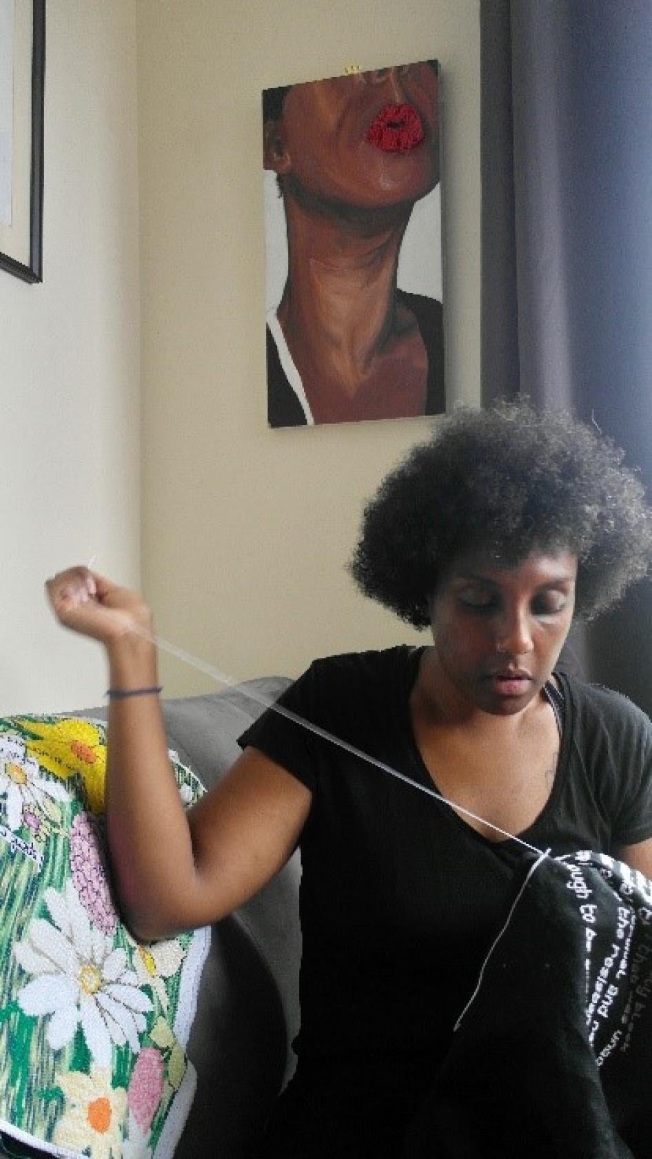 A woman mends a piece of clothing 