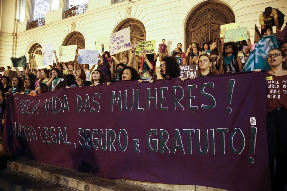 Women hold a banner calling for “legal, safe and free abortion,”