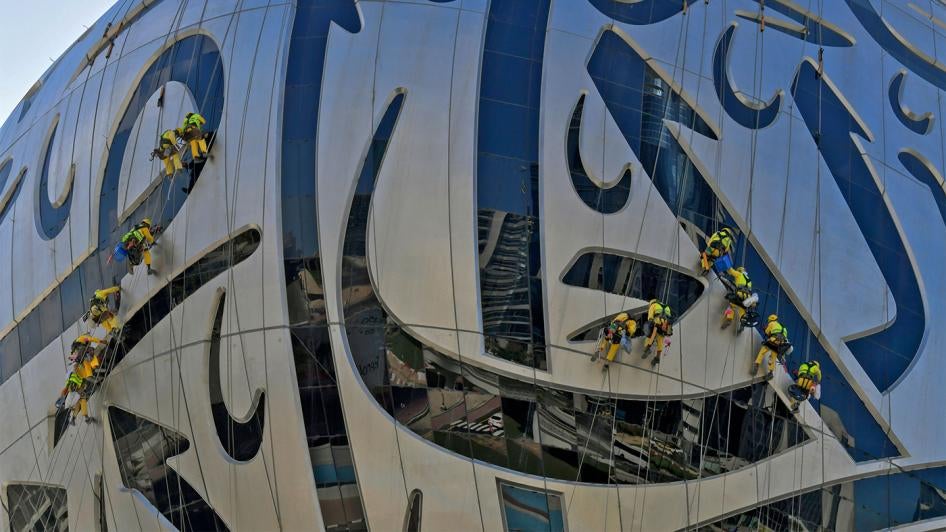 Workers clean the exterior of the Museum of the Future, currently under construction, in Dubai on November 19, 2020.