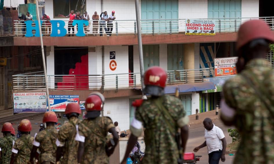 In this file photo, people look down from a balcony as military police deploy in downtown Kampala, Uganda, February 20, 2016. 