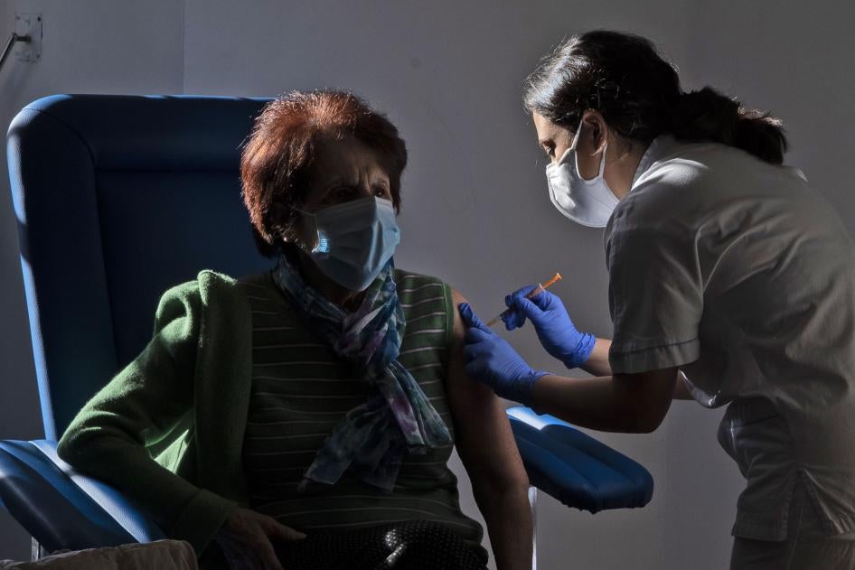 A medical staff member administers a dose of the Pfizer-Biotech vaccine to a person over eighty years old, in the Santa Maria della Pieta hospital in Rome, Italy.