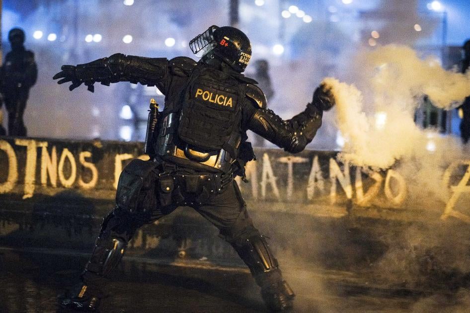 Un agente del ESMAD lanza un cartucho de gas lacrimógeno manualmente a manifestantes el 28 de mayo en Bogotá, Colombia.