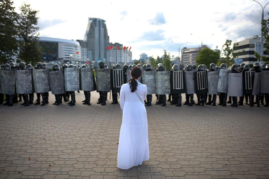 A woman wearing white stands in front of riot police during a Belarusian opposition rally protesting the official presidential election results in Minsk, Belarus, September 13, 2020. 
