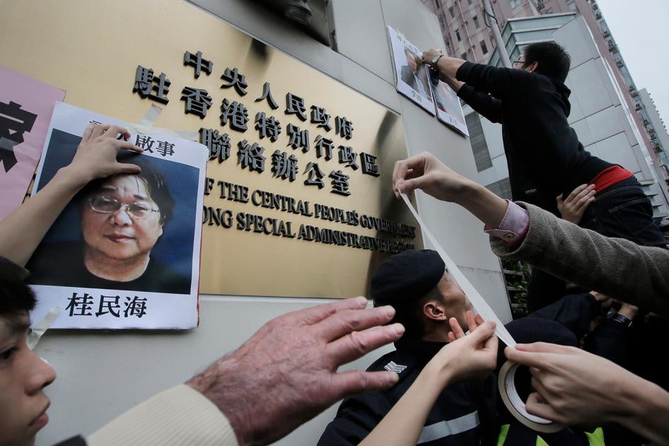Protesters stick photos of Gui Minhai, left, and other missing booksellers outside the Liaison Office of the Central People's Government in Hong Kong on January 3, 2016.