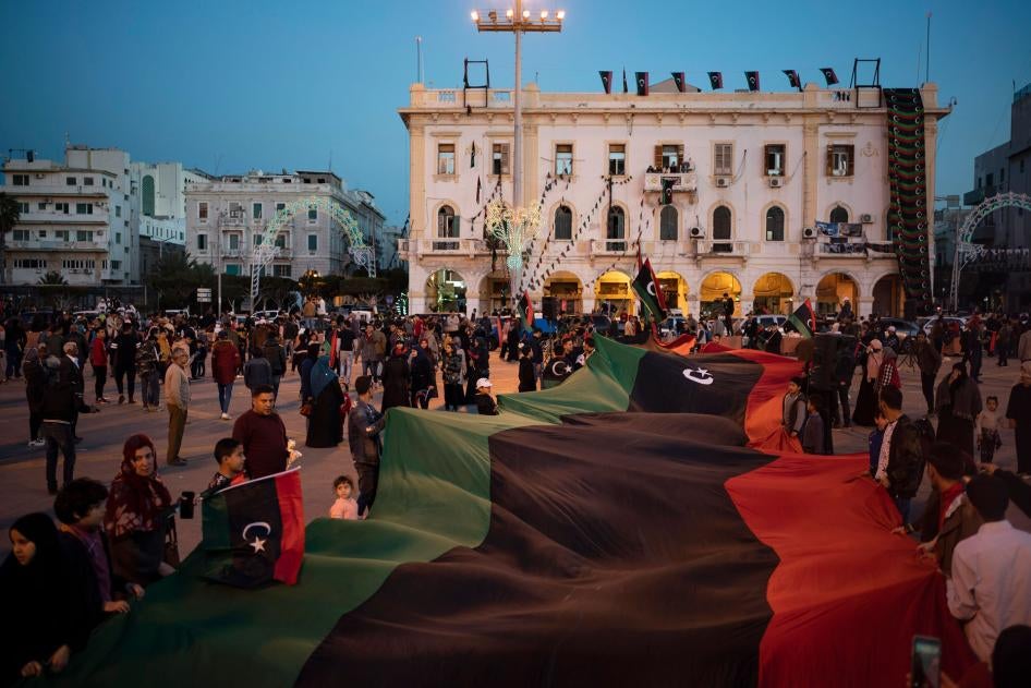 People carry a Libyan flag at Martyr square during a march commemorating the anniversary of protests in Tripoli, Libya, February 25, 2020. 