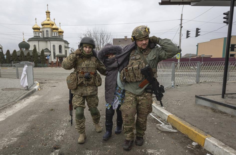 Ukrainian soldiers help a woman in the town of Irpin, Ukraine on March 6.