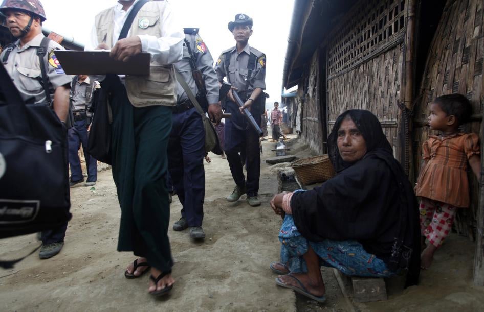 A woman and child watch census workers walk past