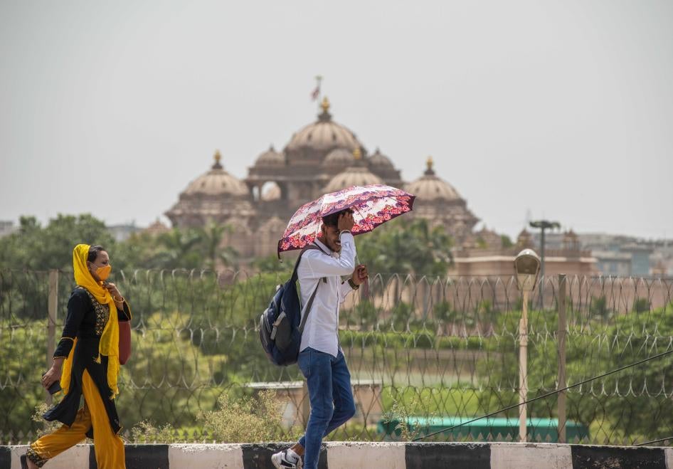 A man shields himself from the sun with an umbrella
