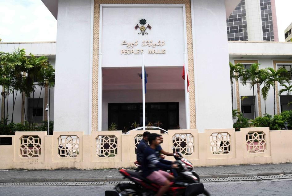 Motorists ride past the People's Majlis