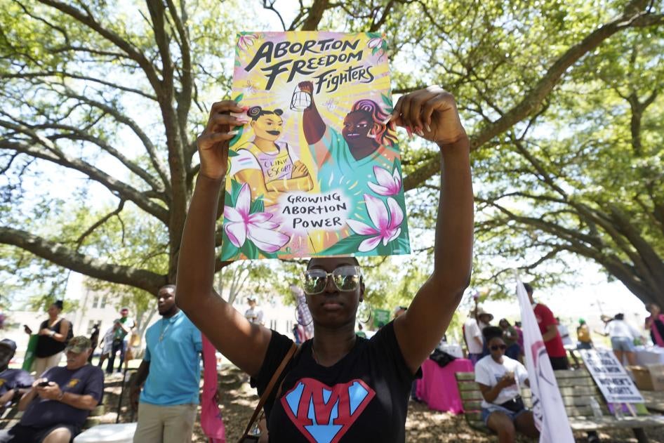 A protester holds a sign that reads "Abortion Freedom Fighters" and "Growing Abortion Power"