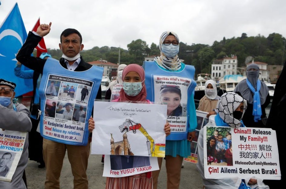 Uyghurs hold pictures of their relatives detained in China