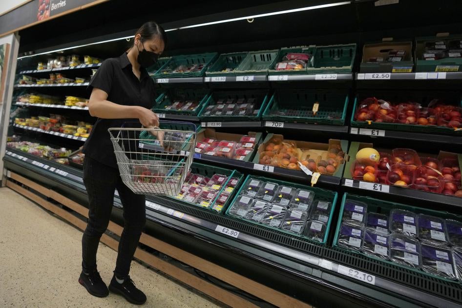 A shopper puts fruit in her basket in a supermarket in London.