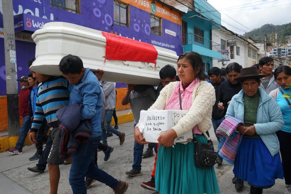 The relatives of 18-year-old Wilfredo Lizarme walk around the city streets with the casket that contains his body, in Andahuaylas, Peru.