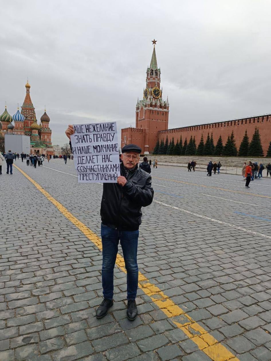 Oleg Orlov protesting Russia's abusive war in Ukraine at the Red Square in Moscow, April 2022. His poster reads, 'Our unwillingness to know the truth and our silence turn us into collaborators in crimes.’