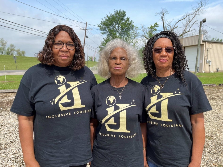 3 women wearing matching shirts pose for a photo