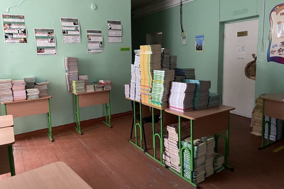 Stacks of textbooks on desks in a classroom