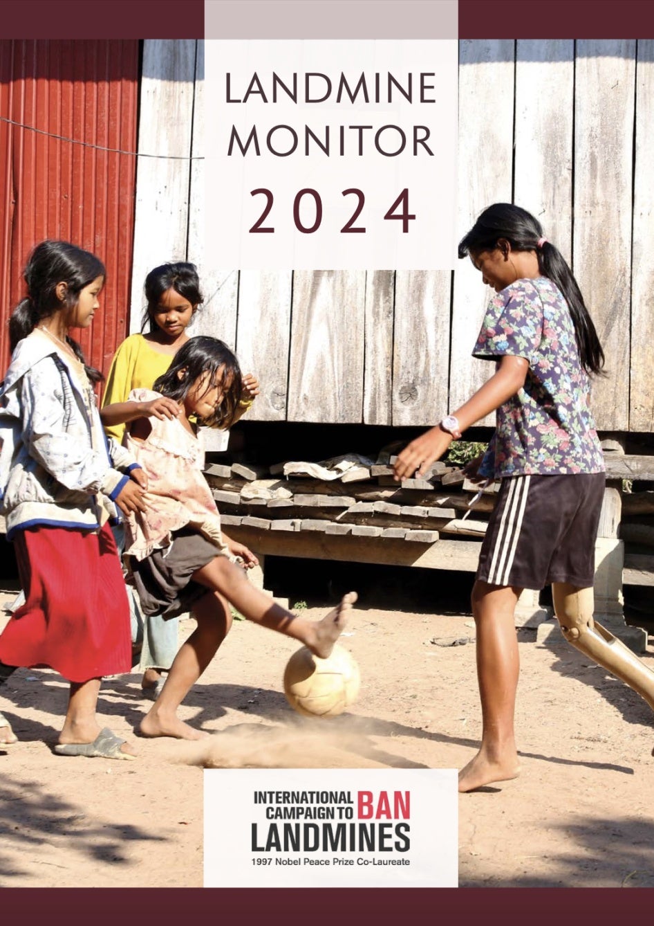La couverture du « Landmine Monitor 2024 », montrant une jeune fille cambodgienne âgée de 13 ans, jouant au football avec ses sœurs dans la province de Kampong Thom, au Cambodge. 